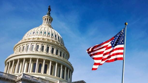 American flag waving with the Capitol Hill in the background